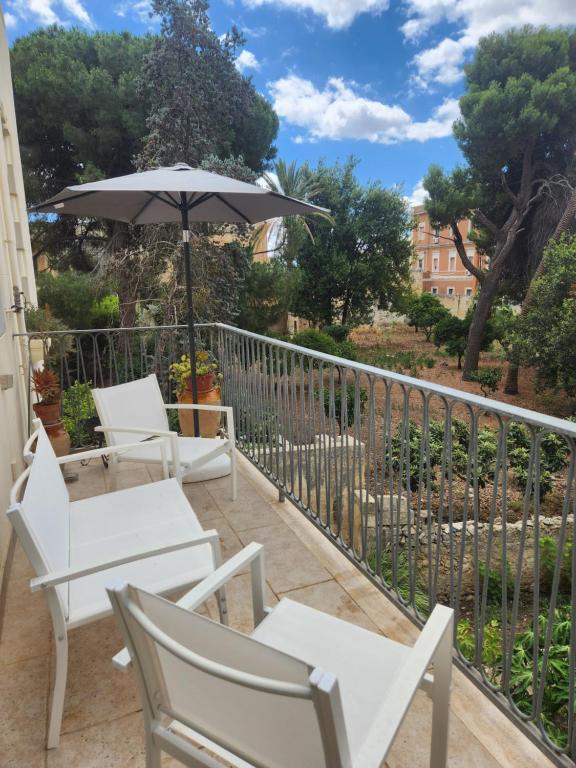 balkon z białymi krzesłami i parasolem w obiekcie Dimora Liberty w mieście Lecce