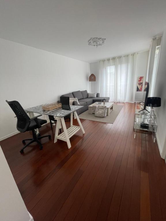 un salon avec un canapé et une table dans l'établissement Lac Zen & Frissons des JO 2024, à Épinay-sur-Seine