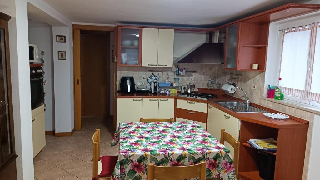 a kitchen with a table and a kitchen with a sink at APPARTAMENTO PAMELA b&b in Grado