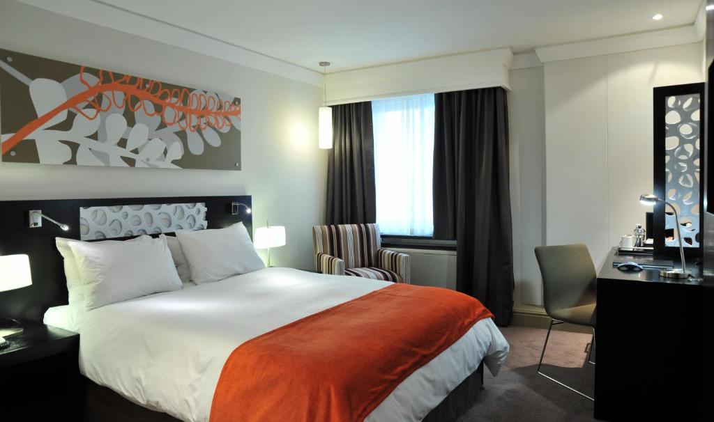 a hotel room with a large bed and a desk at ONOMO Hotel Cape Town – Inn On The Square in Cape Town