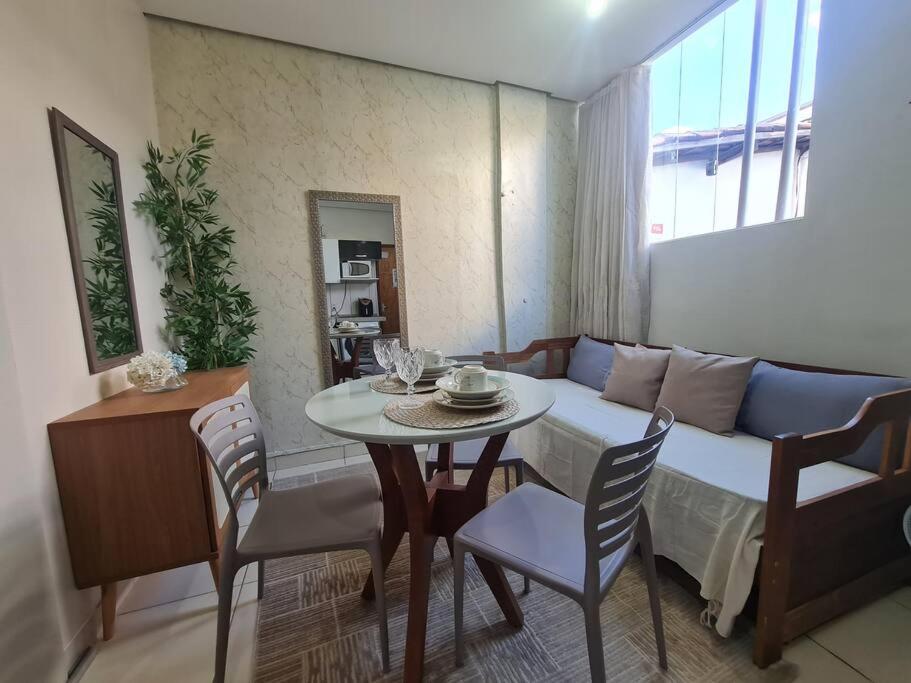 a living room with a table and a couch at Kitnet 105 central com lavadora tv smart e ar condicionado in Montes Claros