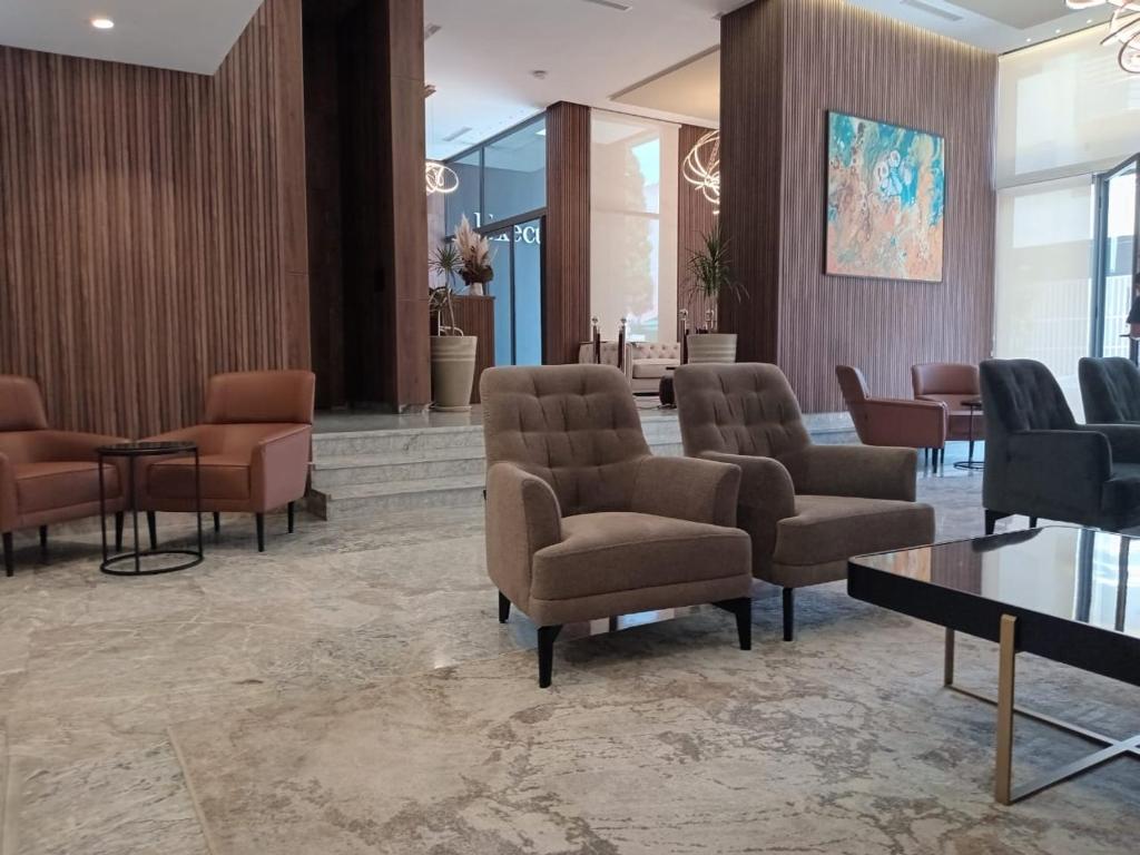 Una zona de espera con sillas y mesas en un vestíbulo. en Executive Boutique Hotel Rabat, en Rabat