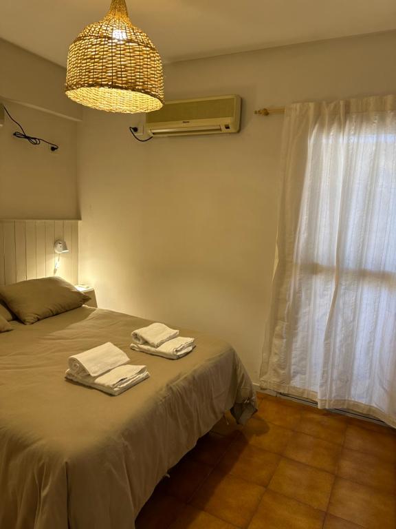 Un dormitorio con una cama con dos toallas encima. en Encantador hogar en Tucumán, en San Miguel de Tucumán