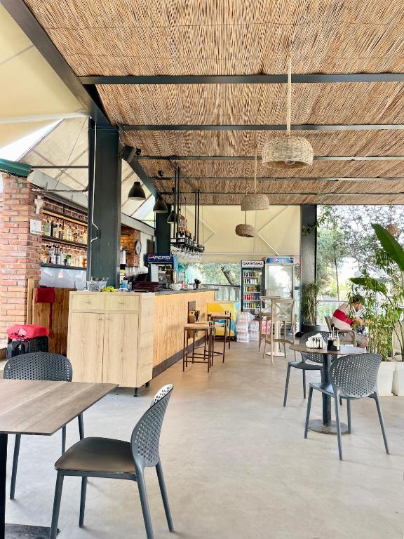 a restaurant with tables and chairs and a bar at Chalet Ambel in Dhërmi