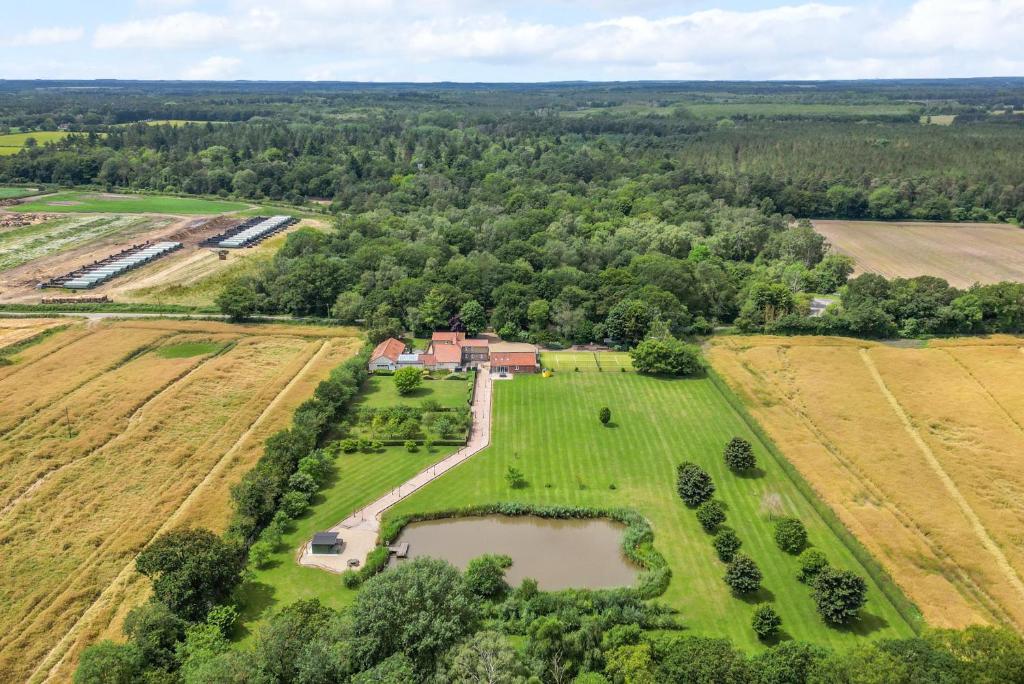 una vista aerea di una fattoria con laghetto di Cottage In Norfolk Sleeps 23 - Private Pool, Fishing Lake, Hot Tub Ref 99008Sc a Hockham