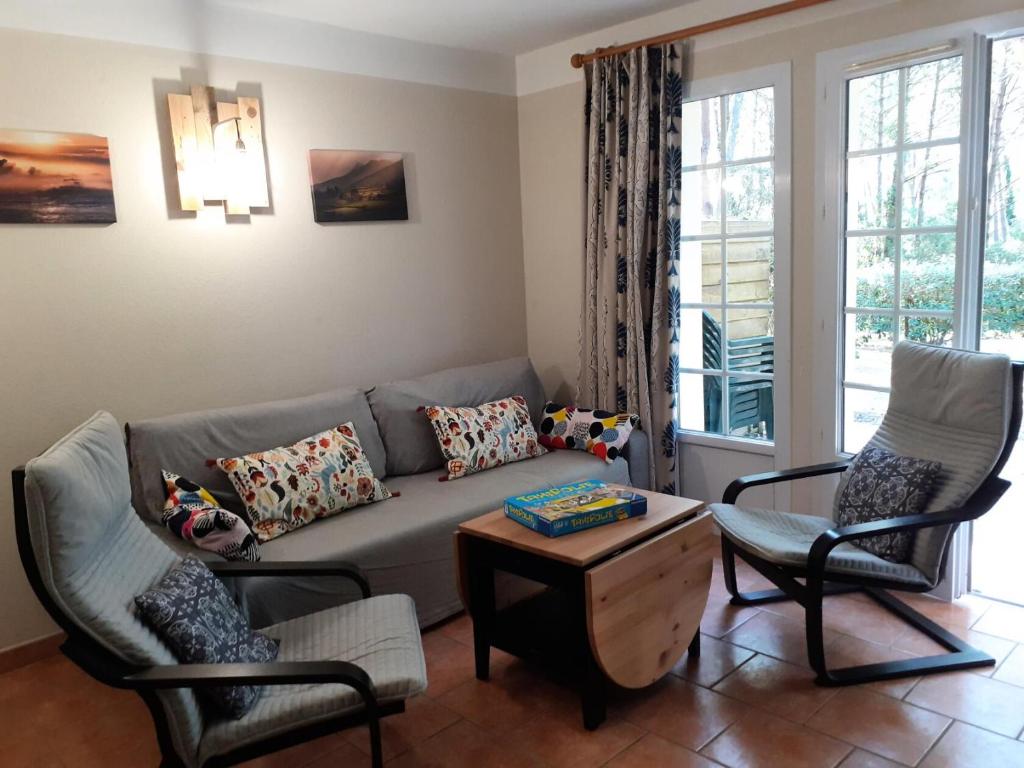 un salon avec un canapé et deux chaises dans l'établissement Les maisons de Moliets - maeva Home - Maison 3 Pièces 6 Personnes - Sélection MAE-5144, à Moliets-et-Maa