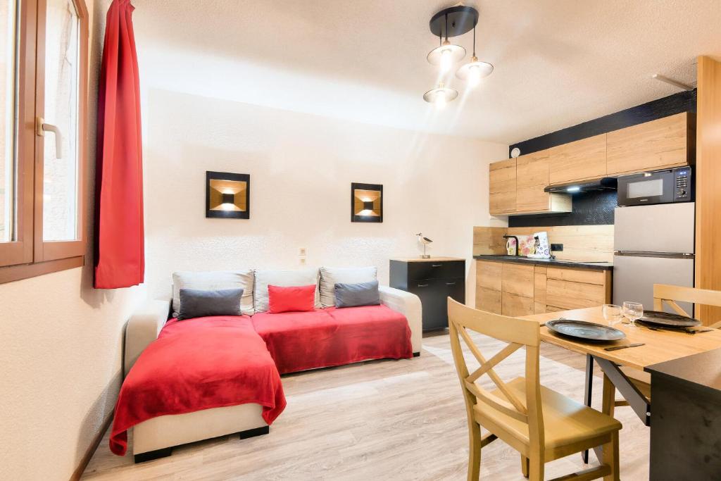 une chambre avec un lit rouge dans une pièce dans l'établissement Résidence Saint-Raphaël Valescure - maeva Home - Appartement vue forêt 2 Pièces 4 Personnes - Prestige - super Home MAE-3314, à Valescure