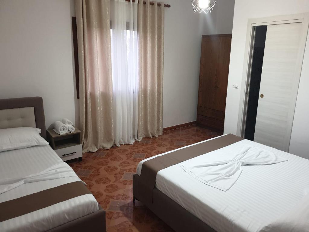 a bedroom with two beds and a window at Centre Vlore Guest House in Vlorë
