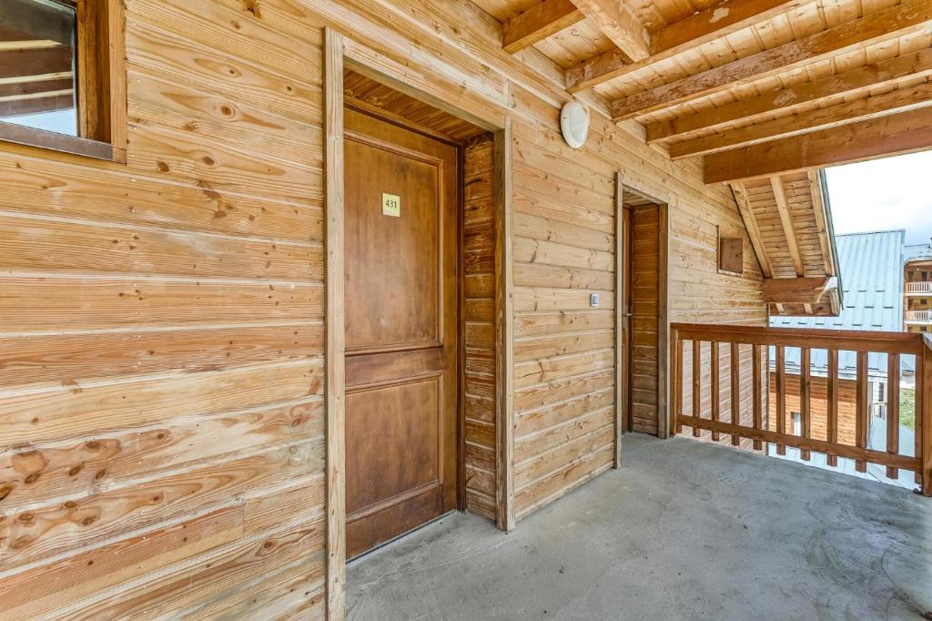 Cette chambre est dotée d'un mur en bois et d'une porte. dans l'établissement Résidence La Crête du Berger - maeva Home - Appartement 2 pièces 6 personnes - Budget MAE-2764, à Agnières-en-Dévoluy