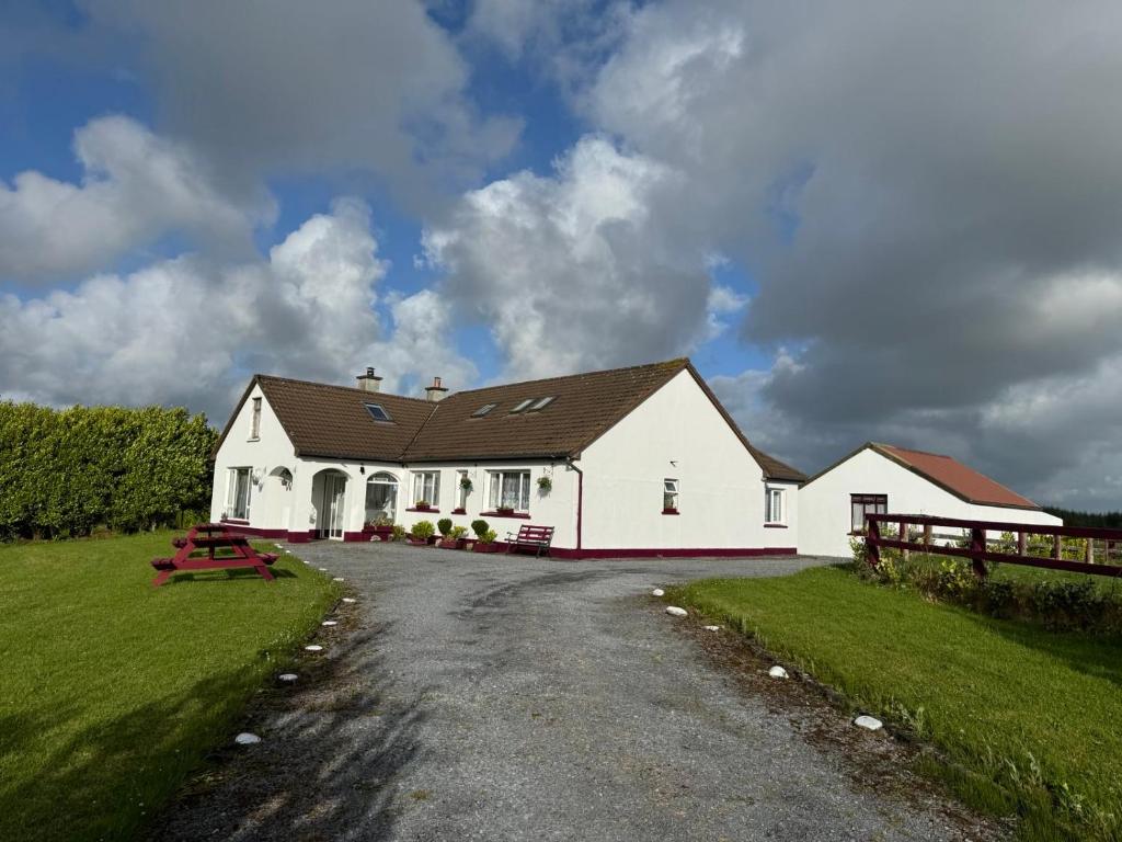 a large white house with a road in front of it at Puffin rooms in Lisdoonvarna