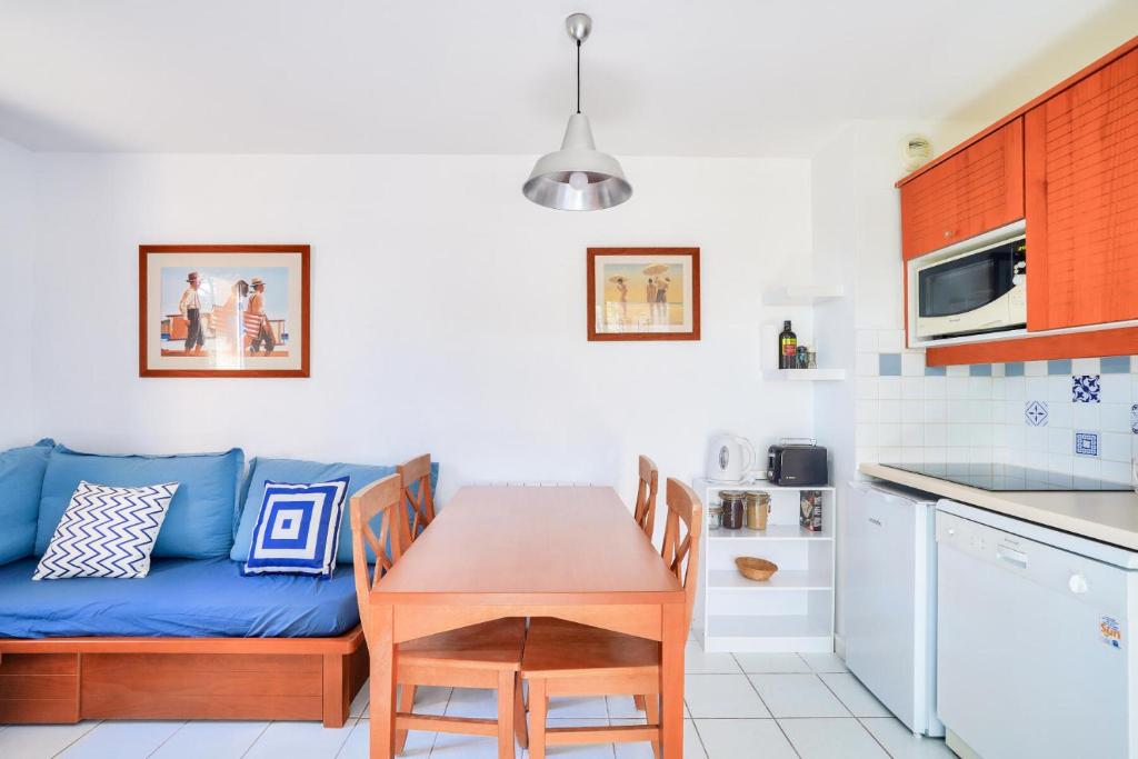 un salon avec un canapé bleu et une table dans l'établissement Résidence Les Grands Pins - maeva Home - Appartement 2 pièces 5 personnes - Prestige MAE-3024, à Maubuisson