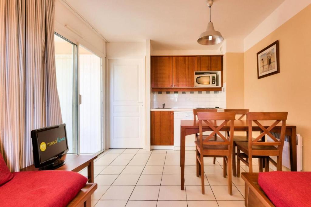 a living room and kitchen with a table and chairs at Résidence Les Grands Pins - maeva Home - Appartement 2 pièces 5 personnes - Confort MAE-0384 in Maubuisson