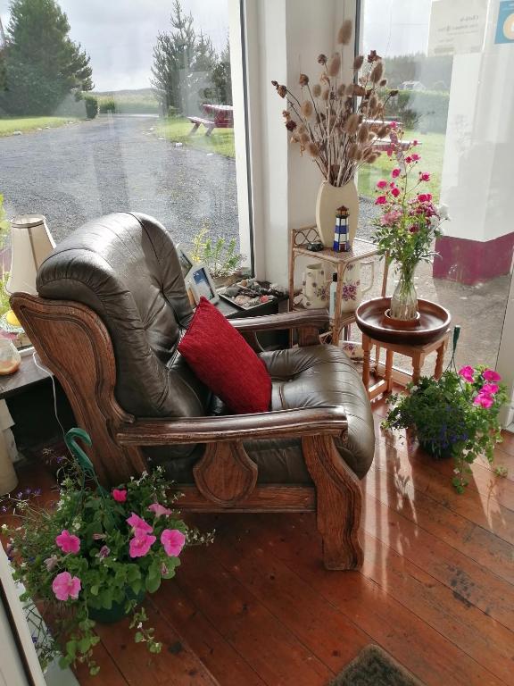 a leather chair with red pillows in a living room at Puffin rooms in Lisdoonvarna