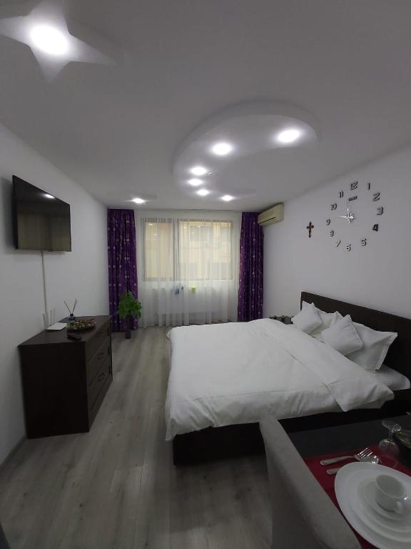 a bedroom with a large white bed and a table at Garsoniera tiglina1 in Galaţi