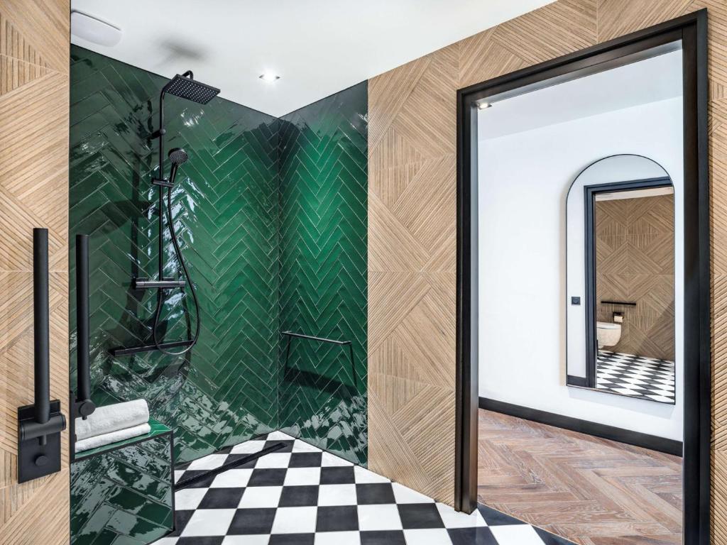 a bathroom with a shower with a checkered floor at Doubletree By Hilton Nice Centre Iconic in Nice