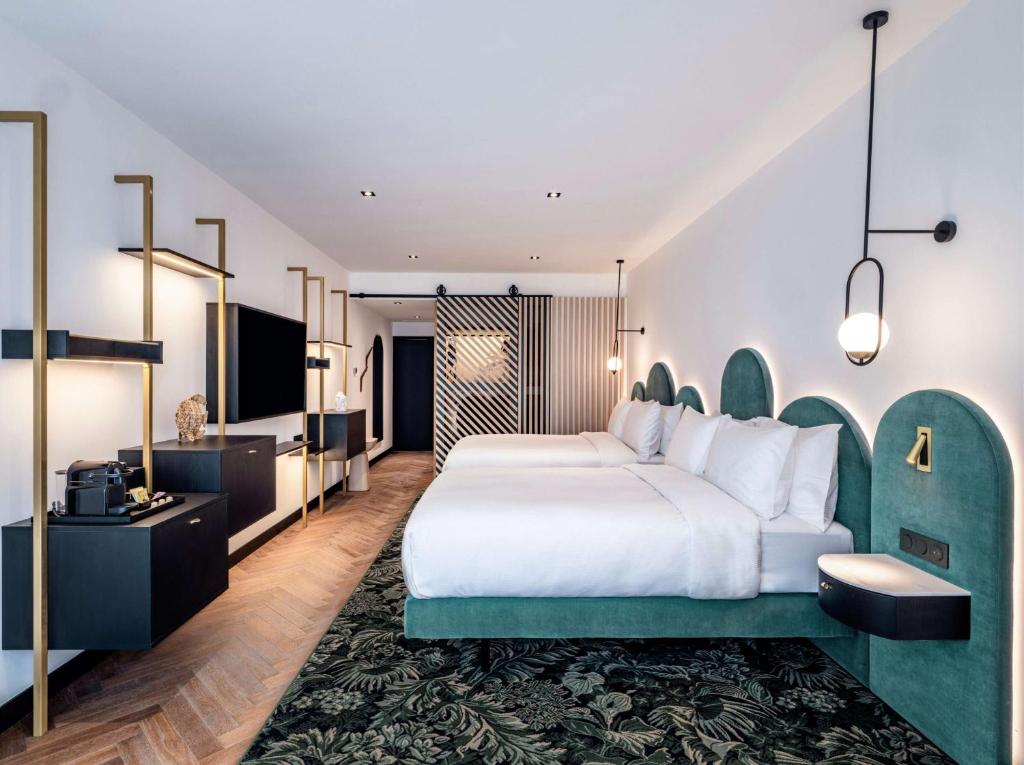 a hotel room with a bed and a flat screen tv at Doubletree By Hilton Nice Centre Iconic in Nice