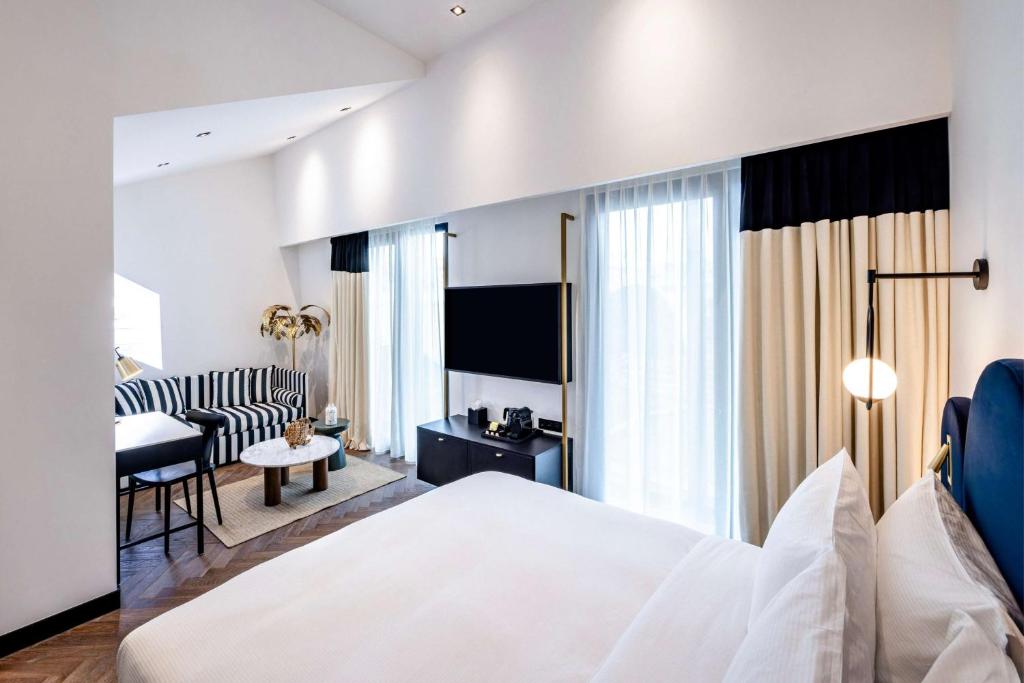 a bedroom with a bed and a living room at Doubletree By Hilton Nice Centre Iconic in Nice