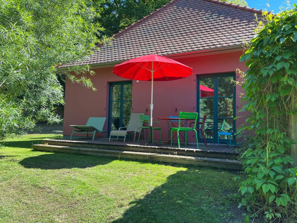 滨湖克拉科Ruhige Ferienwohnung mit großem Garten und Terrasse的一个带桌椅和红色遮阳伞的房子