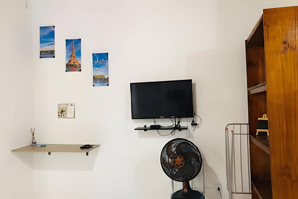 Un televisor de pantalla plana colgado en una pared blanca en Apart recreio dos bandeirantes, en Río de Janeiro