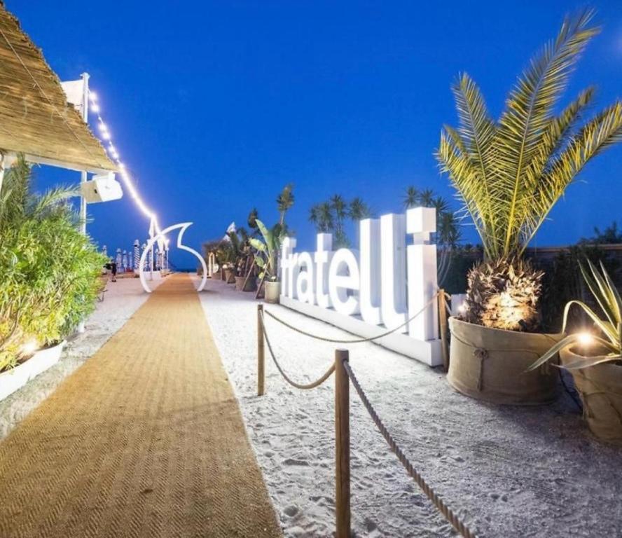 a sign for a hotel on a beach at night at Summerland Nikos Residence in Mamaia