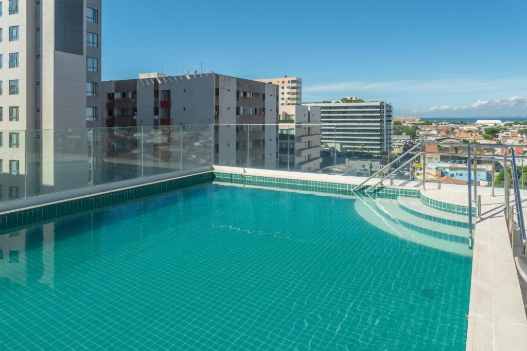 a swimming pool on the roof of a building at Verano Pajuçara by Tropicalis in Maceió