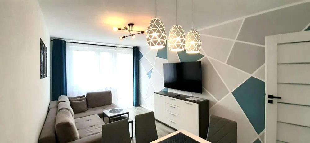 Una sala de estar con un sofá y un televisor. en Apartament SEASIDE Gospody 5a, en Gdansk