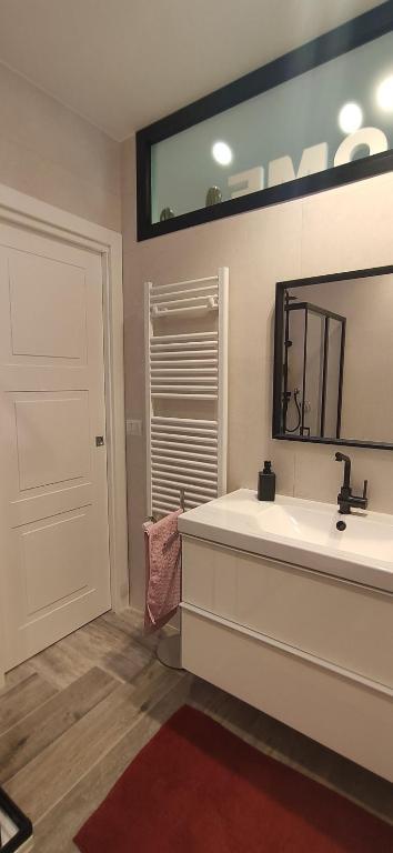 a bathroom with a white sink and a mirror at Home trani in Trani