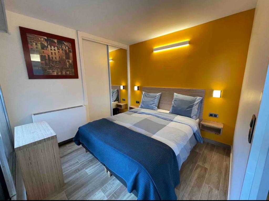 une chambre avec un grand lit avec une couverture bleue dans l'établissement Paris Esplanade 701, à Courbevoie