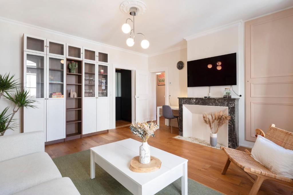 un salon avec un canapé blanc et une cheminée dans l'établissement Le Charlise, à Metz