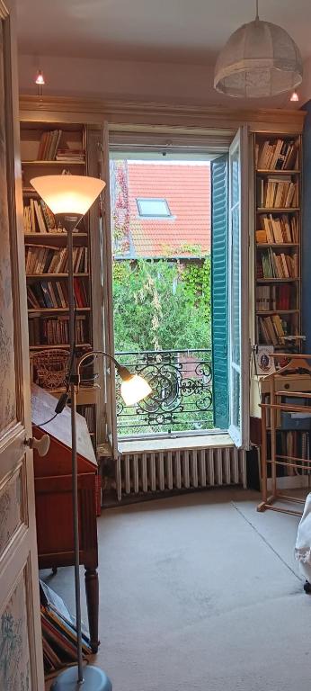 Cette chambre dispose d'une fenêtre, d'un lit et d'un bureau. dans l'établissement Maison BnB pour JO pas loin du centre de Paris, à Asnières-sur-Seine