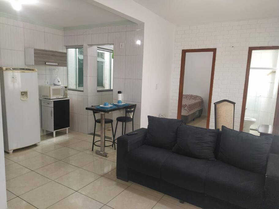 a living room with a couch and a kitchen at Apartamento Encantador 201 in Vitória da Conquista