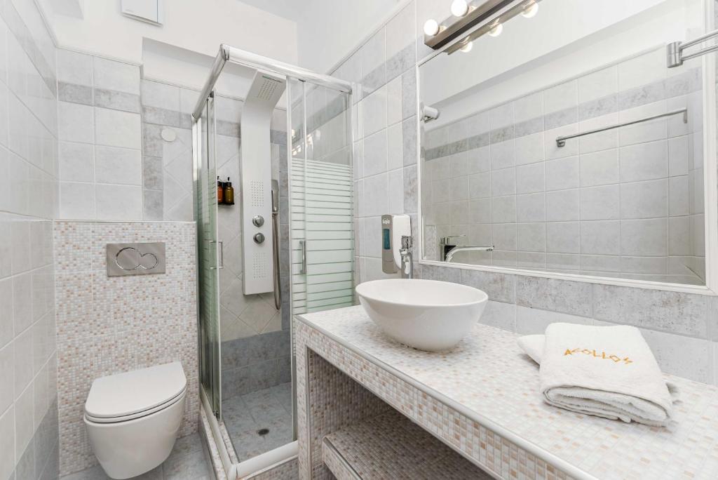 a bathroom with a sink and a toilet and a shower at Hotel Aeollos in Pefkochori