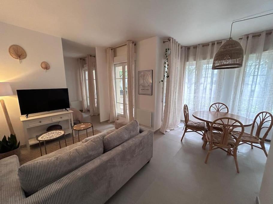 un salon avec un canapé et une table dans l'établissement Studio Wish 5 min Disney Parking, à Chessy