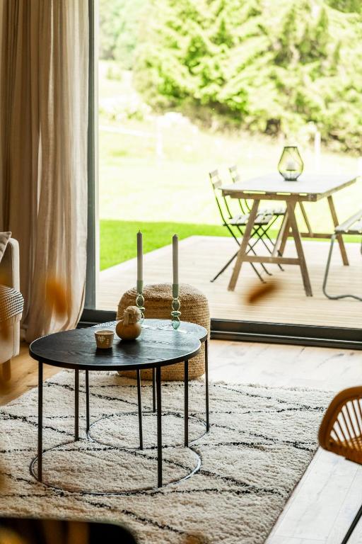 - un salon avec une table et des bougies sur un tapis dans l'établissement Gite de charme dans ancienne ferme en pierre, à Prémanon