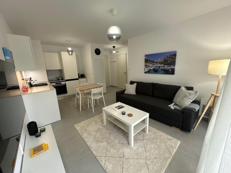 un salon avec un canapé noir et une table dans l'établissement Domaine Eden Golfe 215, à Cogolin