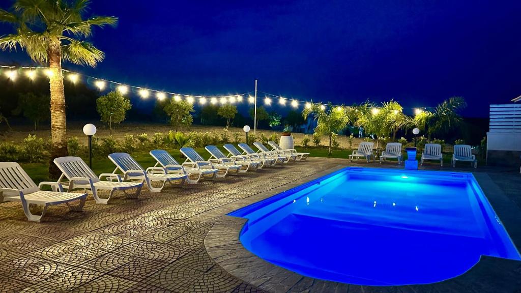 une piscine avec des chaises et un groupe de lumières dans l'établissement Casa Vacanza Errante, à Menfi