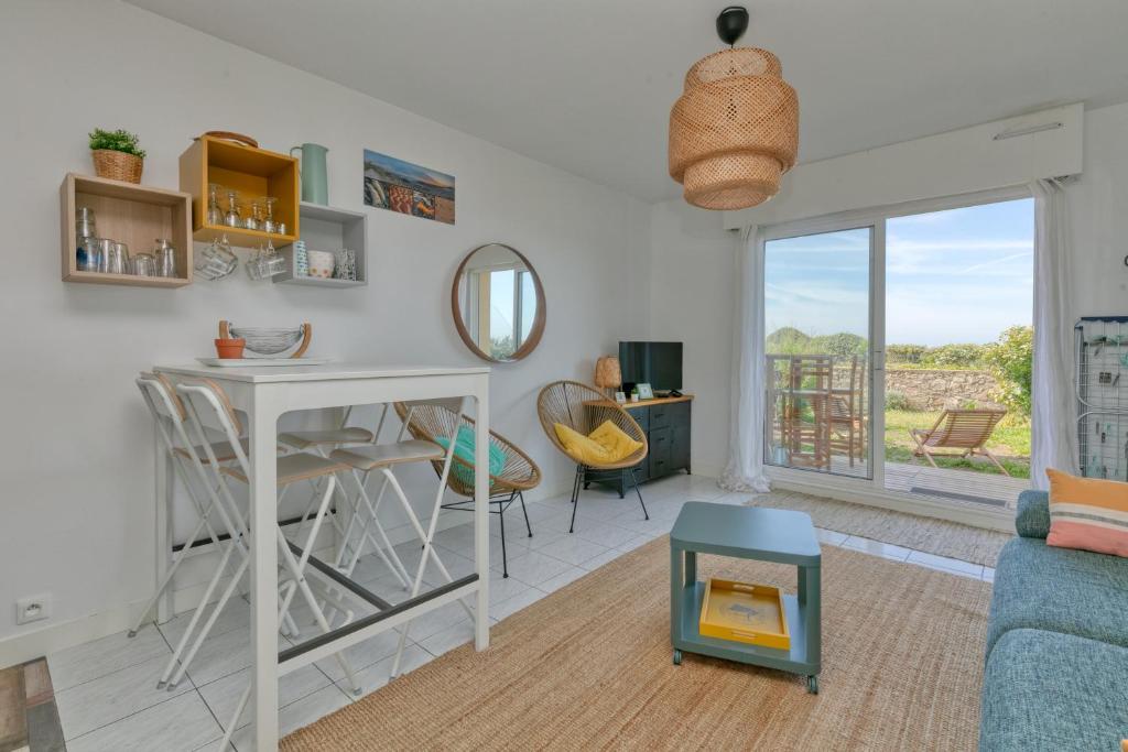 a living room with a table and chairs and a window at Appartement Cosy face à la mer in Le Croisic