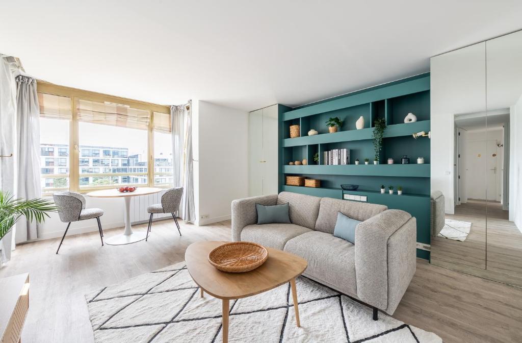 un salon avec un canapé et une table dans l'établissement Bail mobilité I La Defense et Paris en 15min, à Levallois-Perret