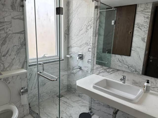 a bathroom with a sink and a glass shower at Oyster court Gulberg in Lahore