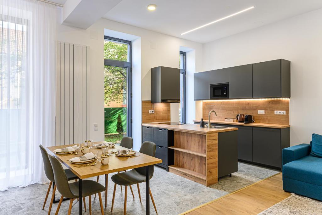 eine Küche mit einem Tisch und einem blauen Sofa in der Unterkunft KOA - Davino Aparthotel in Braşov