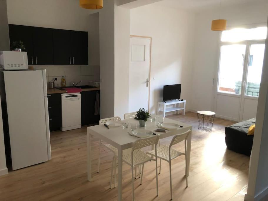 une cuisine et un salon avec une table et des chaises dans l'établissement T3 refait à neuf, lumineux et confortable, à Toulon