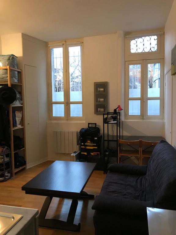 un salon avec un canapé et une table dans l'établissement Joli Cocon Paris 15ème, à Paris