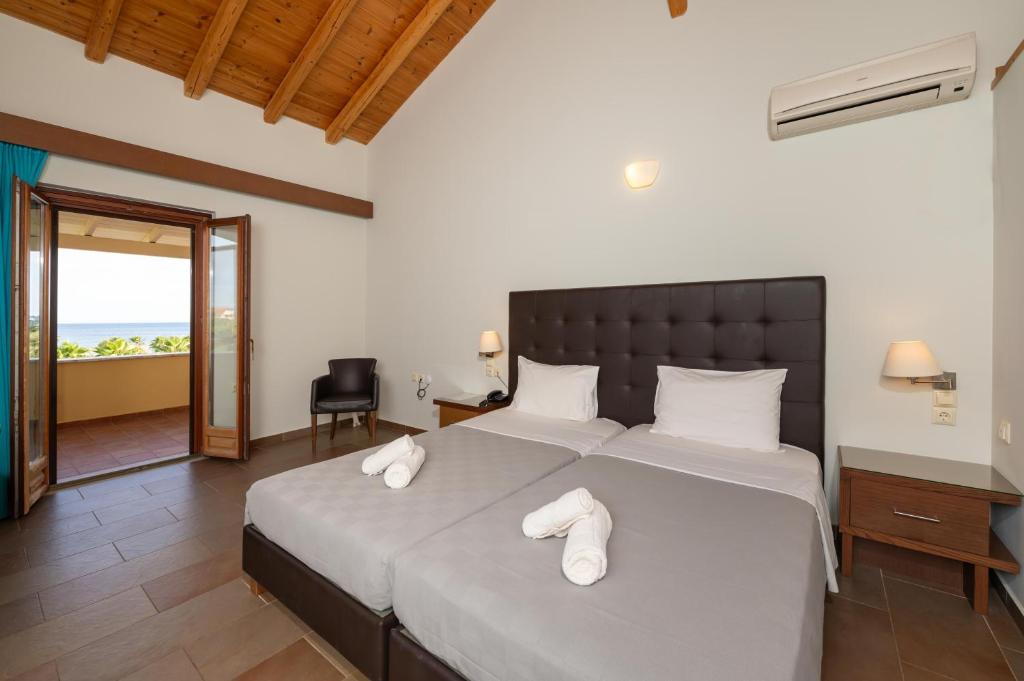 a bedroom with a large bed with white towels on it at Aktaion Resort in Gythio
