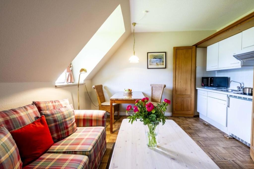 a living room with a couch and a table with a vase of flowers at Neubau 8 in Lüdersburg