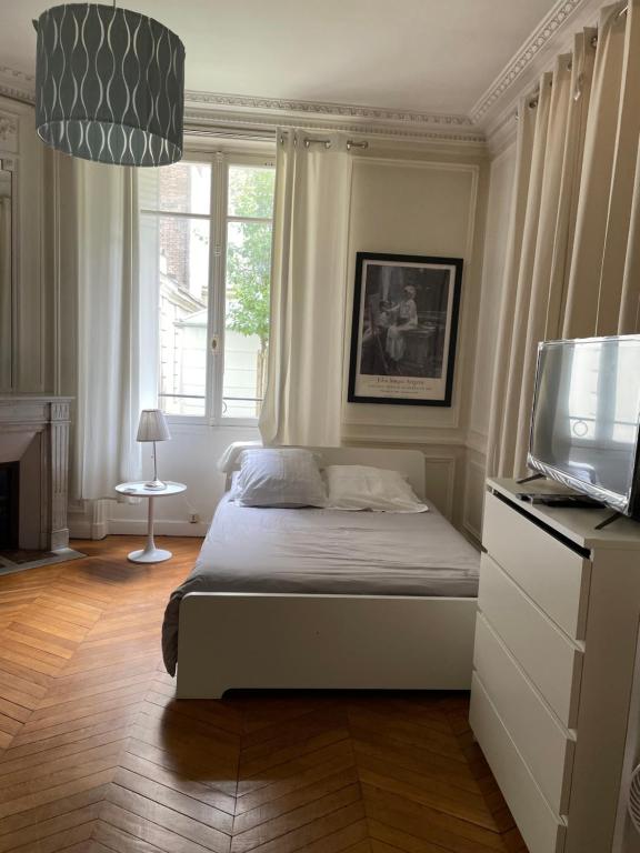 - une chambre avec un lit et une télévision dans l'établissement Studio à Paris près du Pont Mirabeau et Tour Eiffel, à Paris