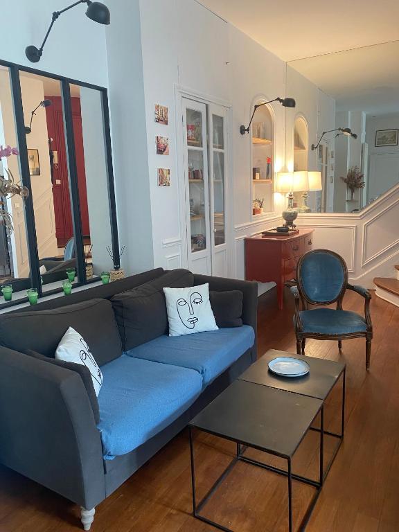 un salon avec un canapé bleu et une table dans l'établissement Kak's apartments Paris, à Paris