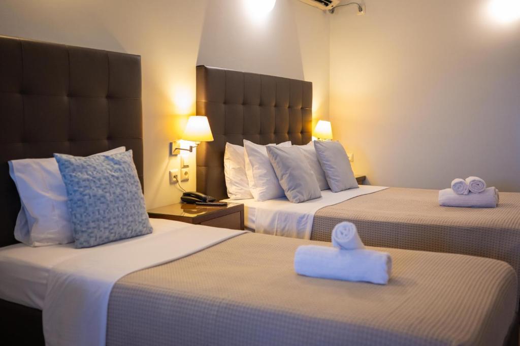 a hotel room with two beds with towels on them at Aktaion Resort in Gythio