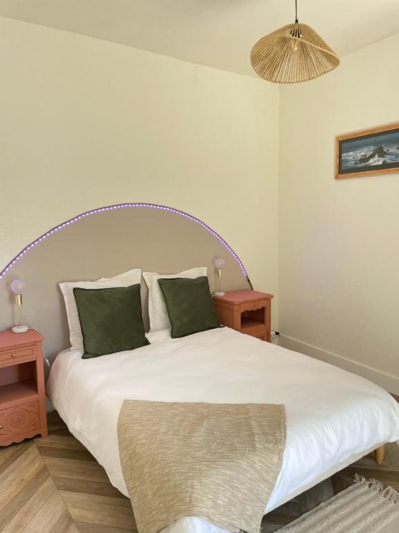 une chambre avec un grand lit blanc avec deux tables dans l'établissement NEW La ferme fleurie Gîte Ty Rose, à Ploubazlanec