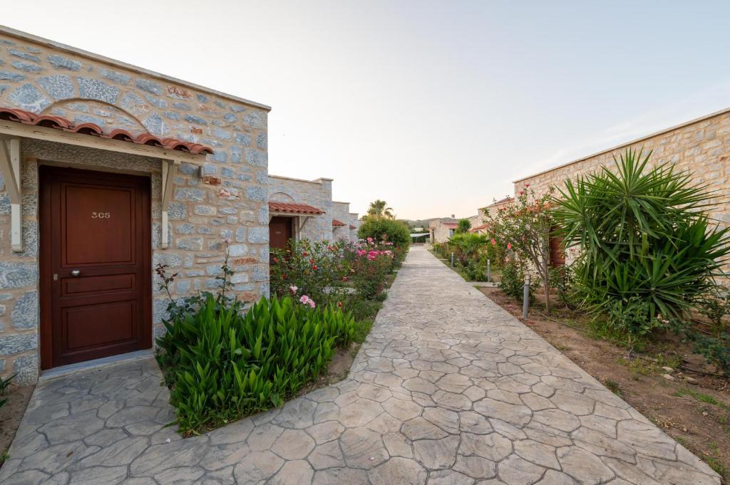 a stone walkway next to a building with a door at Aktaion Resort in Gythio