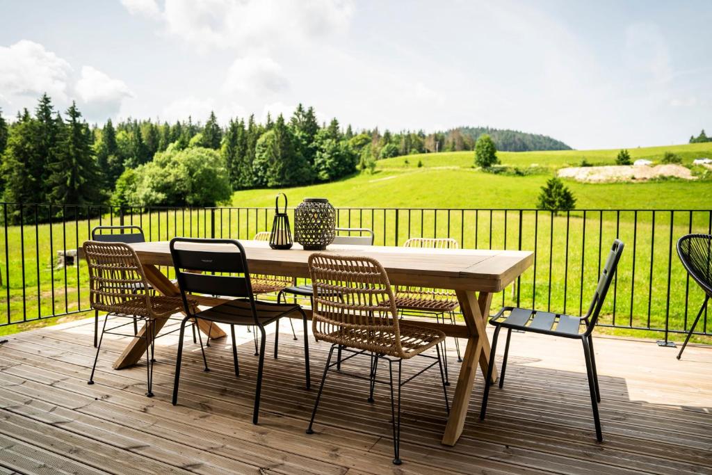 une table et des chaises en bois sur une terrasse en bois dans l'établissement Gite d'exception en pleine nature, à Prémanon